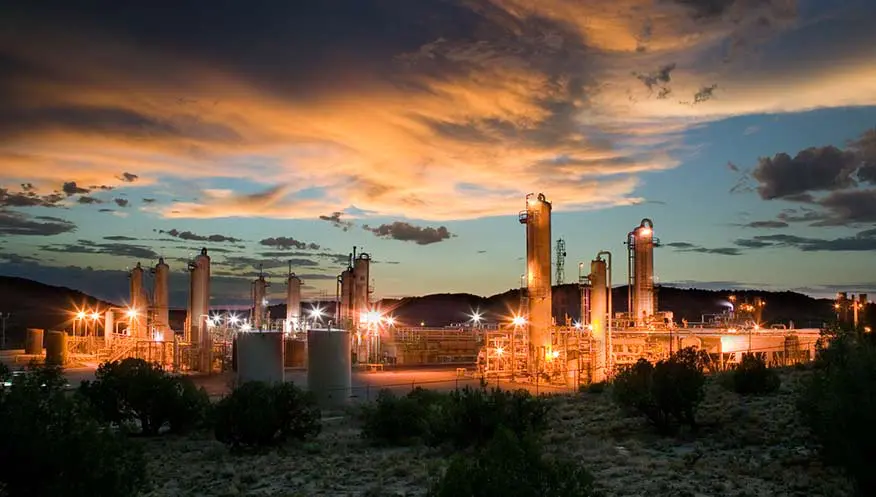 A gas plant with lights on at night.