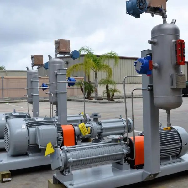 Industrial pumps and motors arranged outdoors.