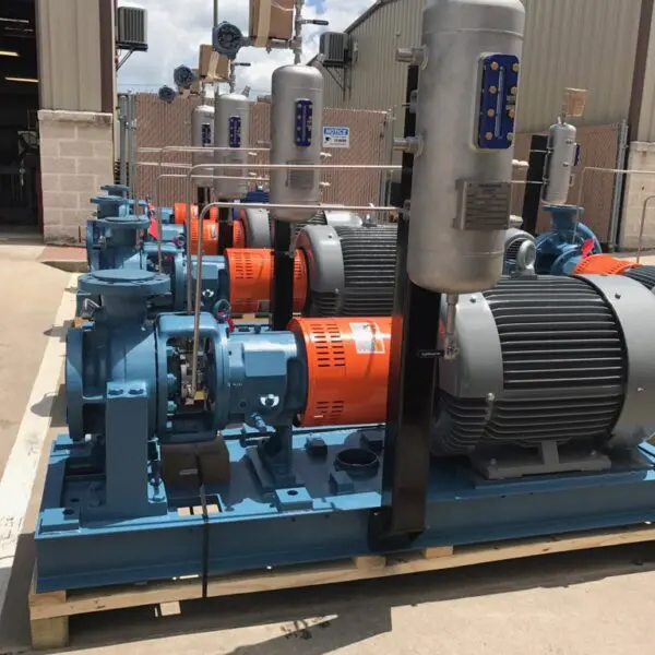 Industrial pumps and motors arranged outdoors.