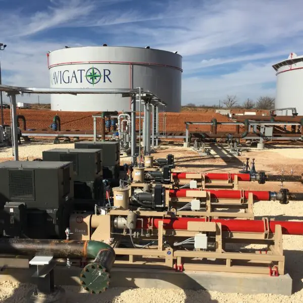 Oil and gas facility with pumps and tanks.