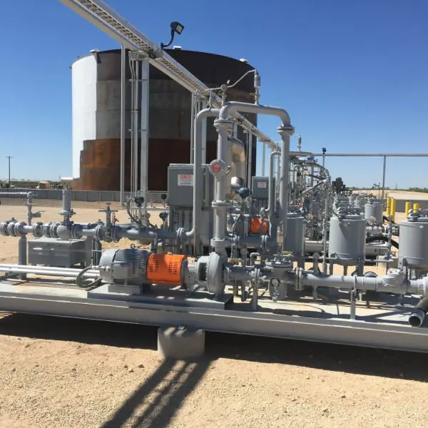 Industrial pumps and pipes at oil site.