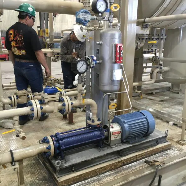 Industrial workers inspecting a pump system.